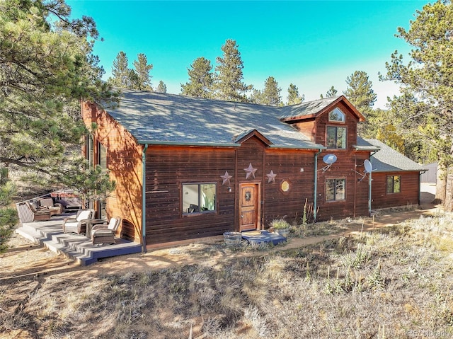 chalet / cabin featuring roof with shingles