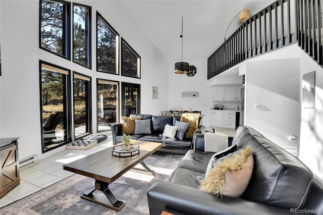 living room featuring a baseboard heating unit, a notable chandelier, light tile patterned floors, and a towering ceiling