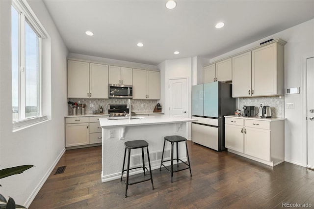 13108 Stoney Meadows Way, Peyton, CO 80831 - kitchen with stainless steel microwave, freestanding refrigerator, backsplash, a kitchen breakfast bar, and light countertops