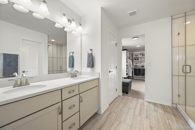 13108 Stoney Meadows Way, Peyton, CO 80831 - bathroom with double vanity, a stall shower, and a walk in closet