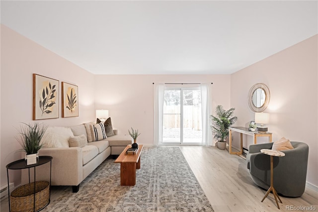 living room with light wood-style flooring and baseboard heating