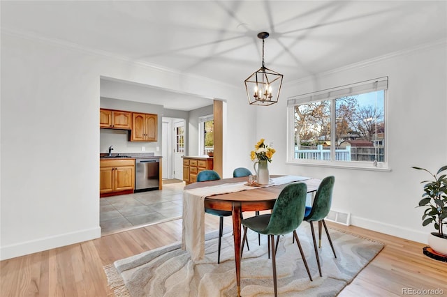 dining space featuring baseboards, an inviting chandelier, visible vents, and light wood-type flooring