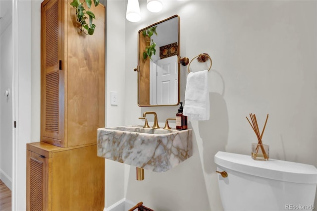bathroom featuring baseboards and toilet