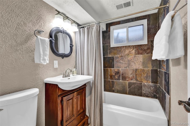 bathroom featuring a textured ceiling, visible vents, shower / bath combo, vanity, and toilet