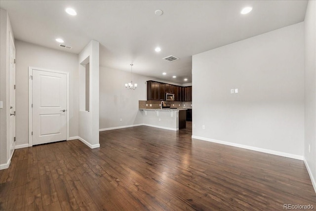 15492 W 65th Ave Unit C, Arvada, CO 80007 - unfurnished living room with a chandelier, dark wood finished floors, and recessed lighting