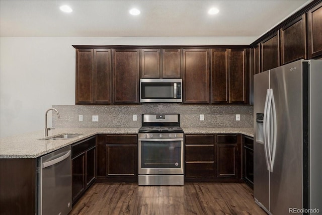 15492 W 65th Ave Unit C, Arvada, CO 80007 - kitchen with appliances with stainless steel finishes, dark brown cabinetry, dark wood-style flooring, a peninsula, and recessed lighting