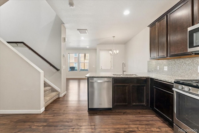 15492 W 65th Ave Unit C, Arvada, CO 80007 - kitchen featuring appliances with stainless steel finishes, a peninsula, light stone countertops, dark wood-type flooring, and recessed lighting