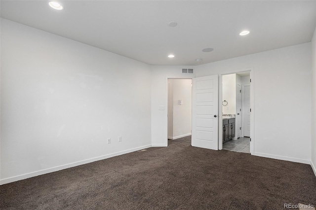 19096 E 55th Ave, Denver, CO 80249 - unfurnished bedroom featuring dark carpet, recessed lighting, baseboards, and connected bathroom