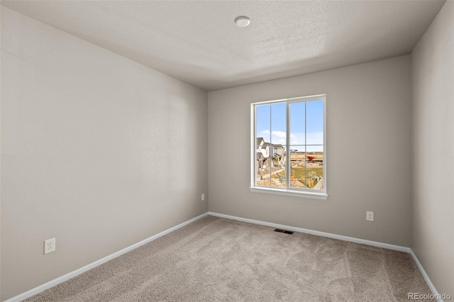 unfurnished room with carpet floors and a textured ceiling