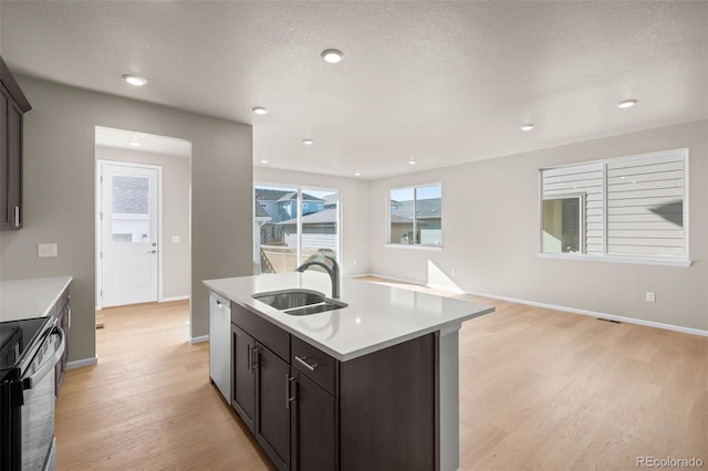 kitchen featuring sink, dishwasher, a kitchen island with sink, dark brown cabinets, and black / electric stove