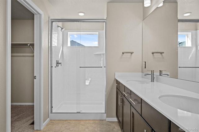 bathroom featuring a shower with door, vanity, and tile patterned flooring