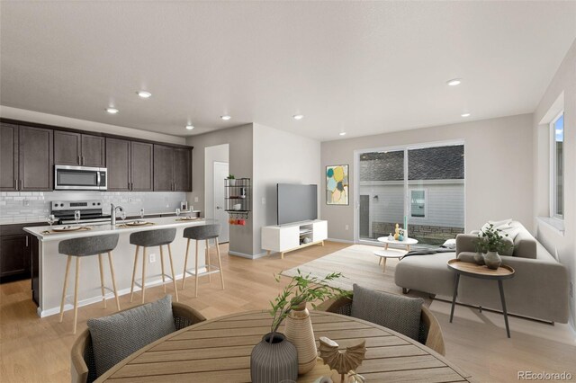 living room featuring sink and light hardwood / wood-style floors