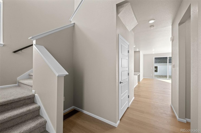 staircase featuring hardwood / wood-style floors and a textured ceiling