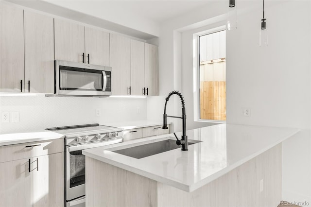 kitchen with appliances with stainless steel finishes, backsplash, hanging light fixtures, and sink