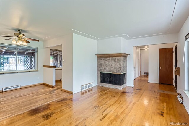 7995 Robin Ln, Denver, CO 80221 - unfurnished living room featuring ceiling fan, wood finished floors, a tiled fireplace, and baseboards