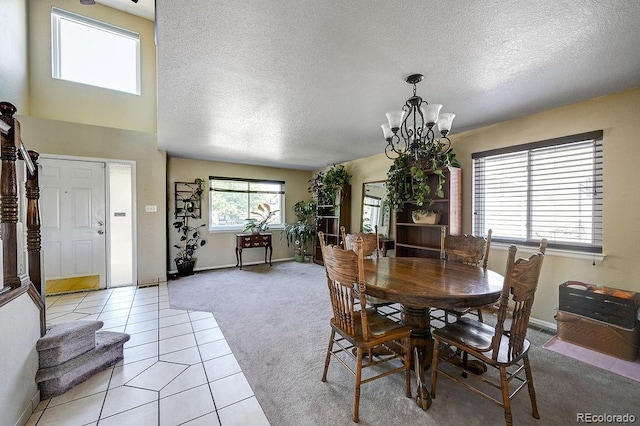 4863 Quail Ct, Frederick, CO 80504 - dining area with light carpet, a chandelier, a textured ceiling, light tile patterned floors, and baseboards