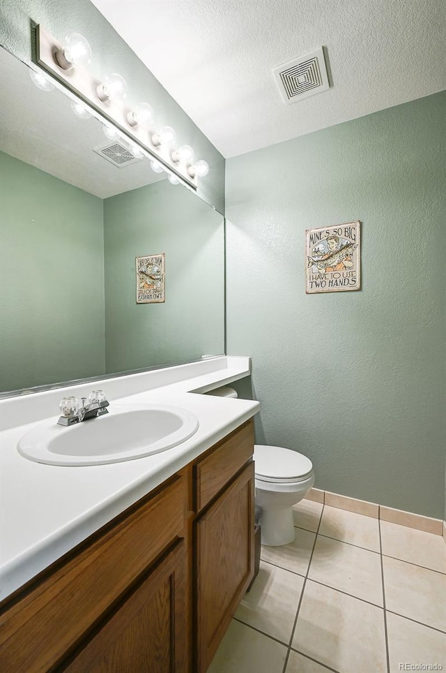 4863 Quail Ct, Frederick, CO 80504 - bathroom with vanity, toilet, tile patterned floors, baseboards, and a textured ceiling