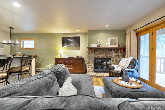 145 Arapahoe Rd Unit 102, Winter Park, CO 80482 - living area featuring wood finished floors, a fireplace, recessed lighting, a chandelier, and a baseboard radiator