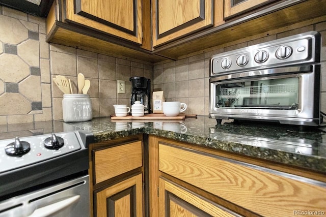 145 Arapahoe Rd Unit 102, Winter Park, CO 80482 - kitchen with electric range oven, backsplash, brown cabinets, and dark stone counters