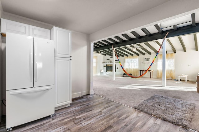 kitchen with hardwood / wood-style flooring, white refrigerator, lofted ceiling with beams, and white cabinets