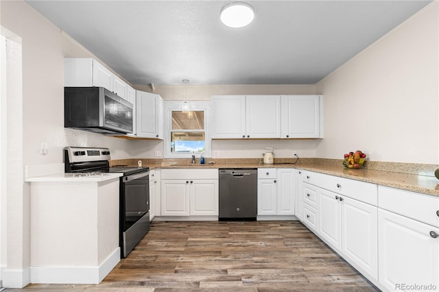 kitchen with white cabinets, stainless steel appliances, hardwood / wood-style floors, and sink