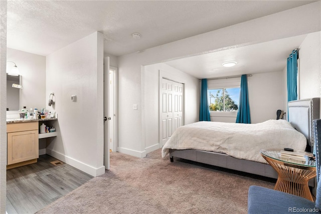 bedroom featuring light hardwood / wood-style flooring, a textured ceiling, and a closet