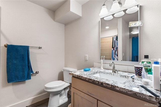 bathroom with vanity, toilet, and wood-type flooring