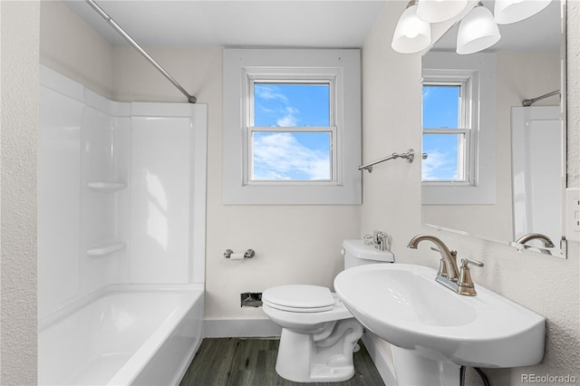 full bathroom with toilet, hardwood / wood-style flooring, bathing tub / shower combination, and plenty of natural light