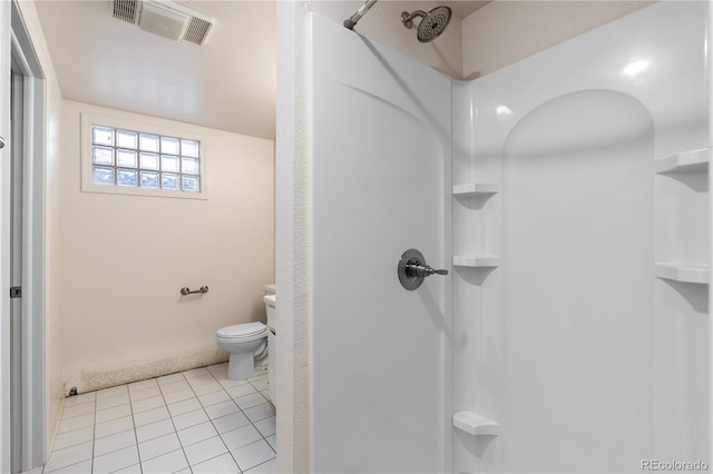 bathroom featuring toilet, a shower, and tile patterned flooring