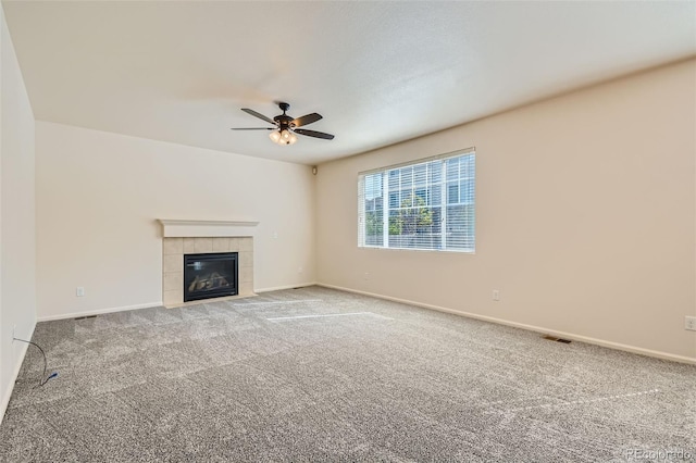 unfurnished living room featuring carpet, a fireplace, visible vents, a ceiling fan, and baseboards