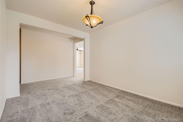 carpeted spare room featuring baseboards