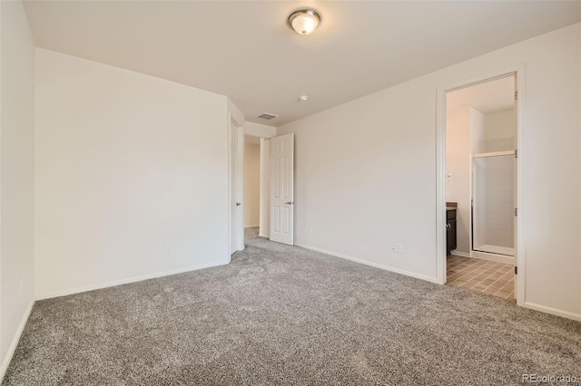 unfurnished bedroom with ensuite bath and carpet flooring