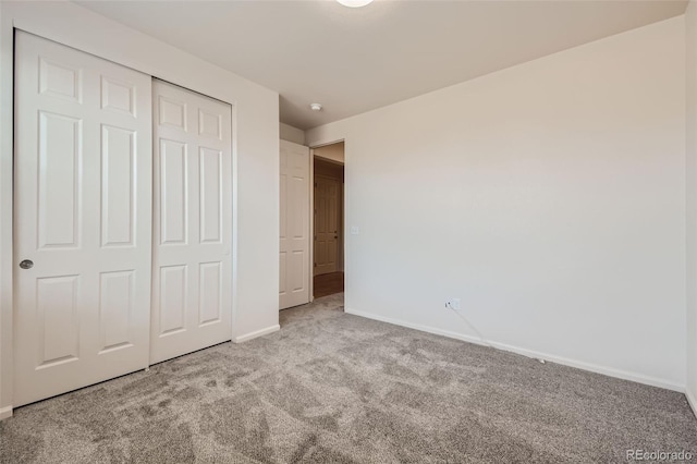 unfurnished bedroom featuring a closet and light colored carpet