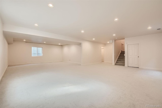 basement with recessed lighting, light carpet, stairway, and baseboards