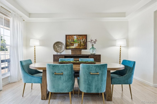 dining space with a wealth of natural light, baseboards, and light wood-type flooring