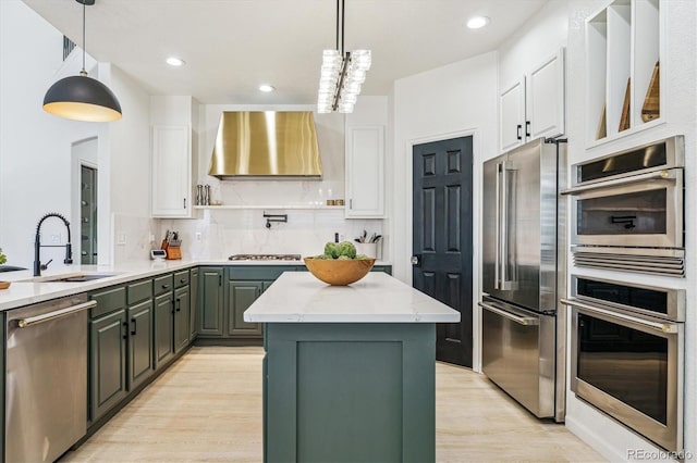 kitchen featuring a sink, wall chimney exhaust hood, stainless steel appliances, white cabinets, and light wood-type flooring