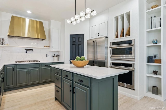 kitchen featuring light wood finished floors, white cabinetry, wall chimney exhaust hood, and high end refrigerator