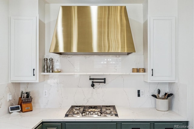 kitchen featuring open shelves, stainless steel gas stovetop, decorative backsplash, and exhaust hood