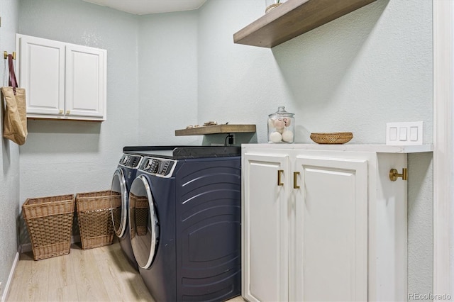laundry room featuring washing machine and dryer, cabinet space, and wood finished floors