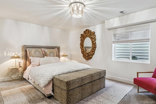 carpeted bedroom featuring baseboards and visible vents