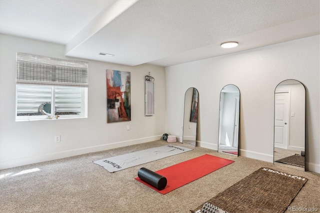 exercise area featuring carpet flooring, baseboards, and visible vents