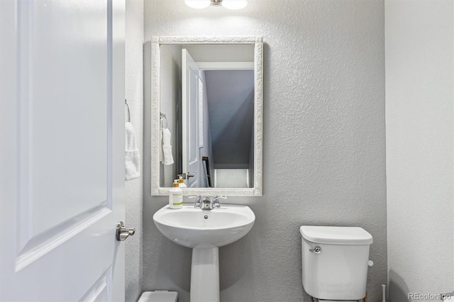 4260 E Warren Ave Unit 5, Denver, CO 80222 - bathroom featuring toilet, a textured wall, and a sink