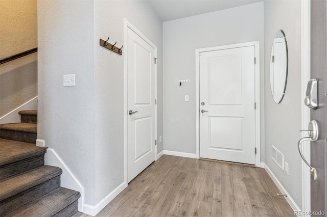 4260 E Warren Ave Unit 5, Denver, CO 80222 - foyer entrance featuring light wood-style floors, stairway, and baseboards