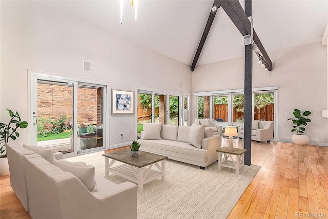 living room featuring high vaulted ceiling, beamed ceiling, and light hardwood / wood-style flooring