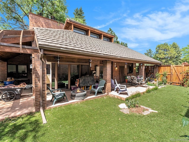 rear view of house featuring a lawn, a patio, and an outdoor fire pit