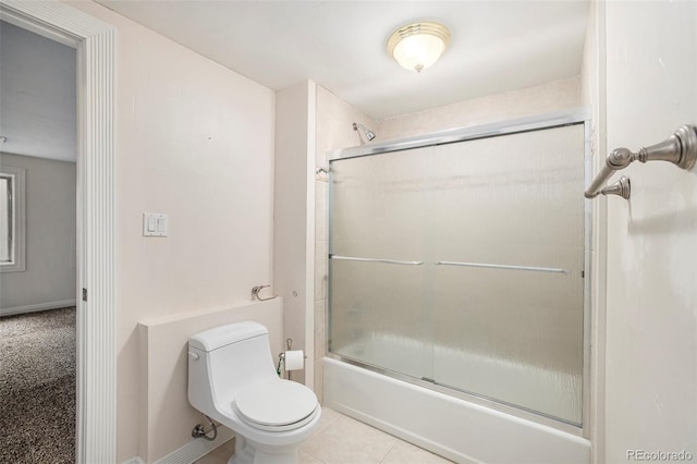 bathroom with toilet, tile patterned floors, and combined bath / shower with glass door