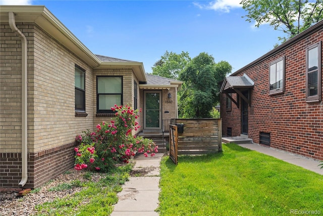 1540 Filbert Ct, Denver, CO 80220 - doorway to property with brick siding, a lawn, and a shingled roof