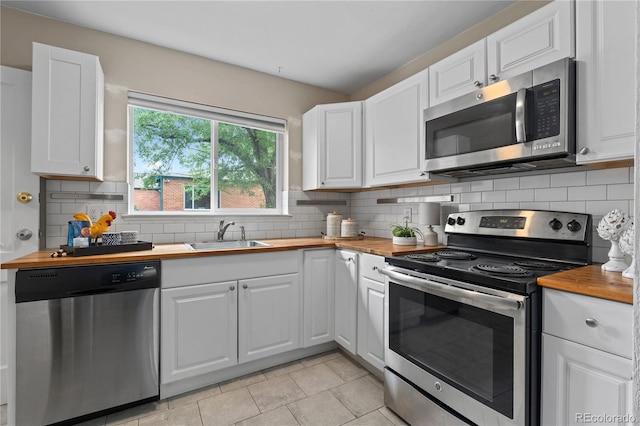1540 Filbert Ct, Denver, CO 80220 - kitchen with stainless steel appliances, butcher block counters, a sink, and white cabinets
