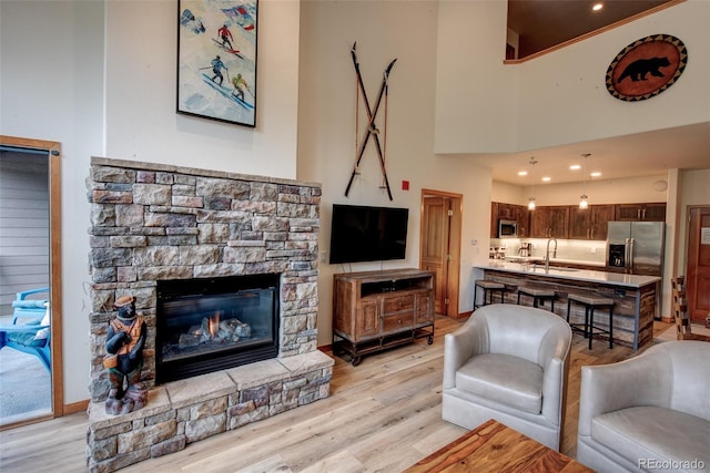 23110 US Highway 6 Unit 5040, Keystone, CO 80435 - living area with a fireplace, light wood-style flooring, and a towering ceiling