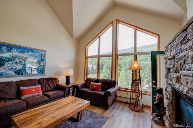 23110 US Highway 6 Unit 5040, Keystone, CO 80435 - living room featuring lofted ceiling, light wood finished floors, a baseboard heating unit, a fireplace, and plenty of natural light